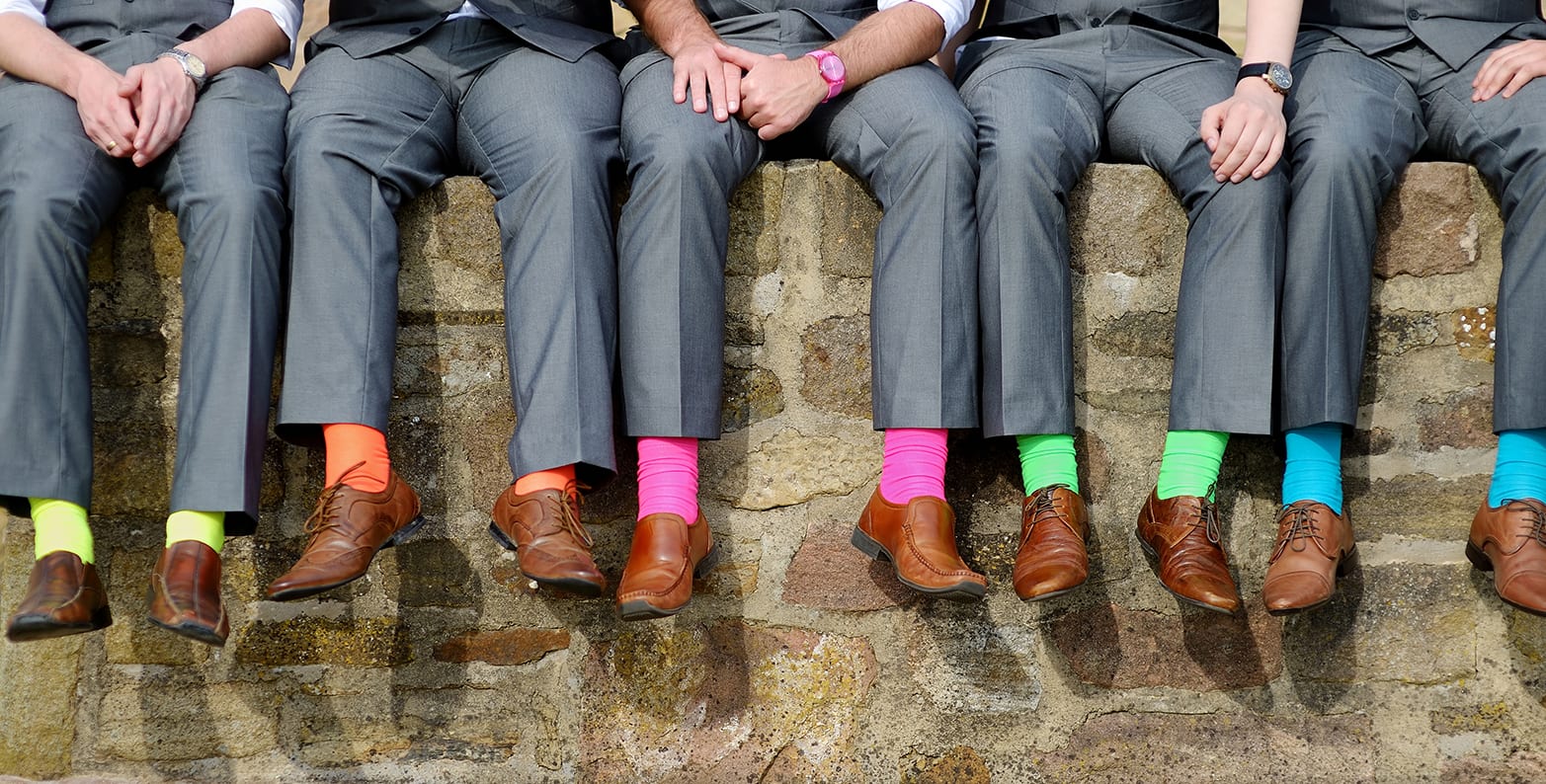 Men in gray suits wearing colorful socks as a style detail in menswear